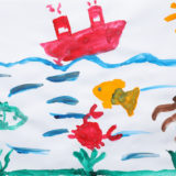 A child's painting of a ship and marine life